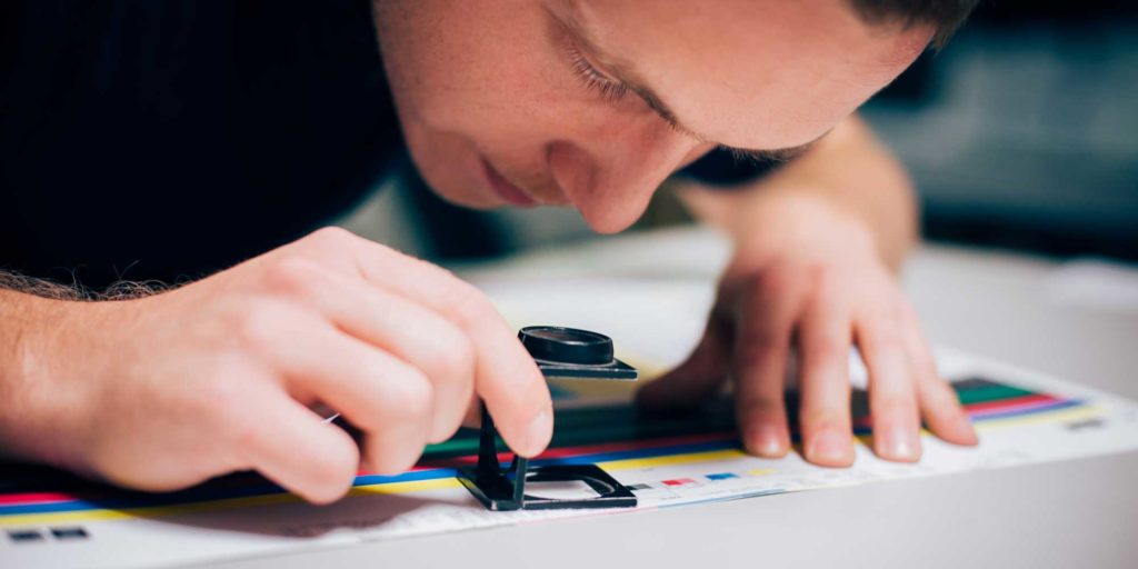 een man die met een vergrootglas op een blad papier kijkt